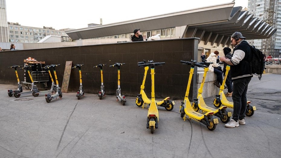    Пассажир вышел из метро и арендует электросамокат на стихийной парковке СИМ рядом с метро. Автор фото: Тихонов Михаил