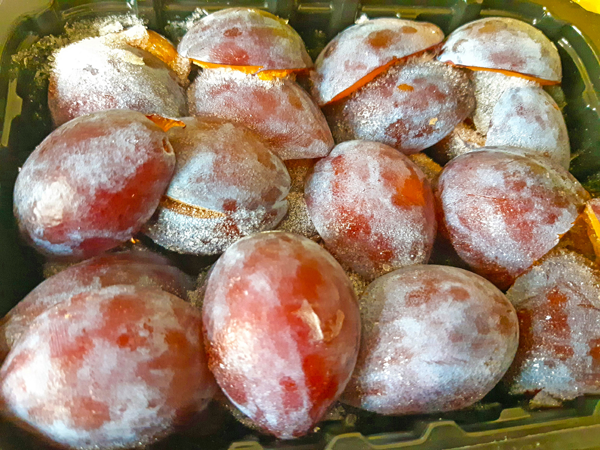 Половинки сливы в контейнерах