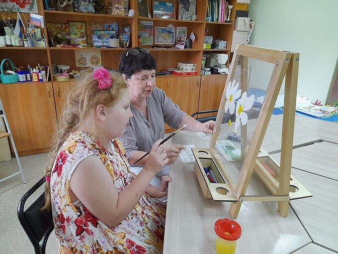 Девочка рисует на прозрачном мольберте под руководством Некрасовой Татьяны Николаевны