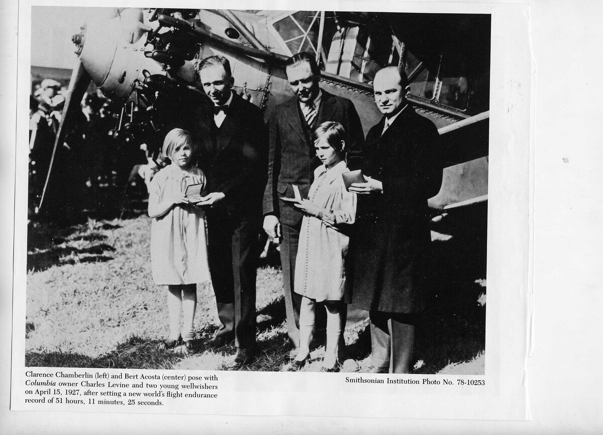 Кларенс Чемберлин (слева) и Берт Акоста (в центре) позируют с владельцем самолета Bellanca WB-2 Miss Columbia Чарльзом Левином и двумя приветствующими их девочками 15 апреля 1927 года, после установления нового мирового рекорда продолжительности полета — 51 час 11 минут 25 секунд. Снимок wikipedia.org
