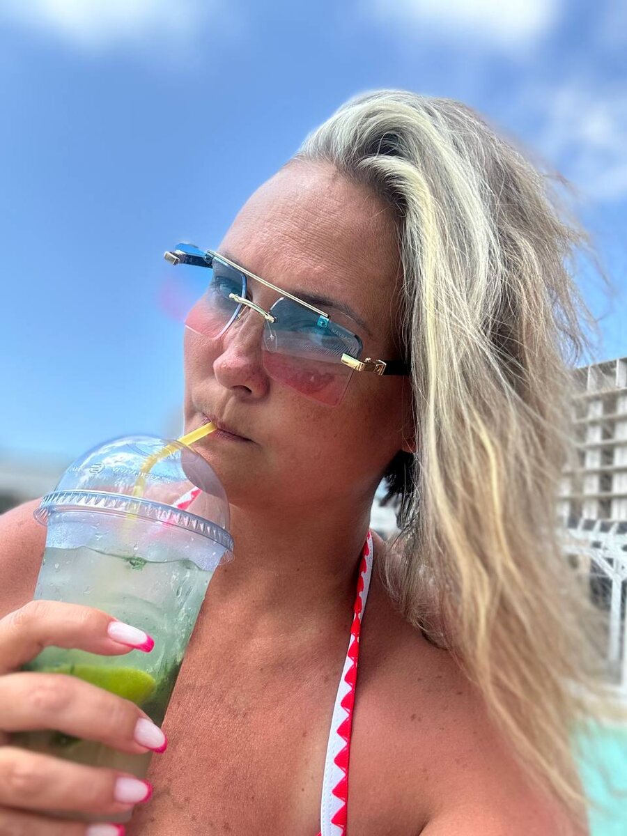 Жена пьет коктейль в отеле