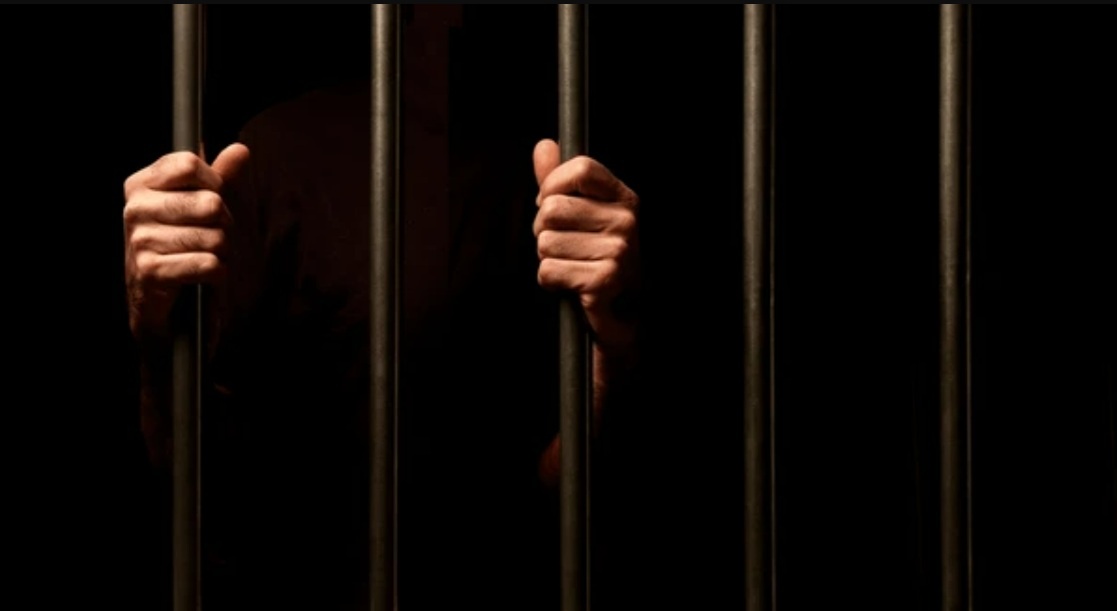 Преступник за решеткой. Источник: shutterstock.com