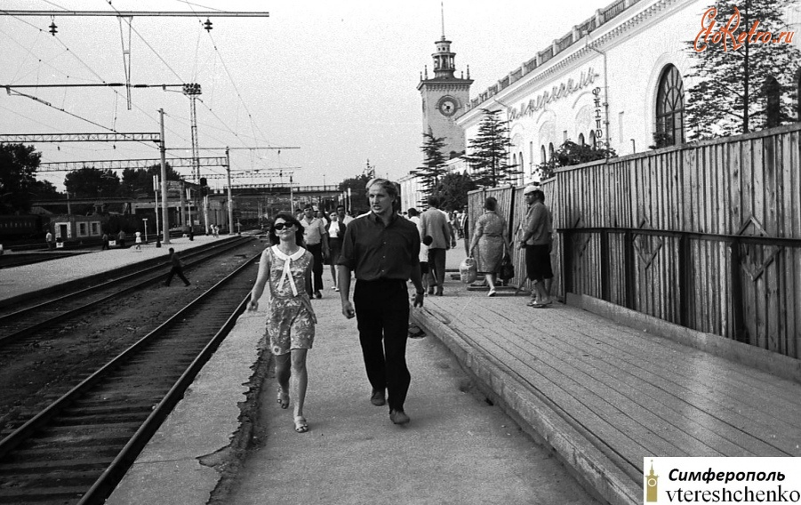Фотоиллюстрация: 1971. Город Симферополь. Железнодорожный вокзал "Симферополь пассажирский". Автор фотографии: Валерий Сергеевич Втерешенко. На его фото тот самый дощатый перрон и то место, где идут друзья фотографа из Польши, напротив которого остановился тот самый купейный вагон, в котором мы ехали до Калининграда (Пионерский) трое суток. Именно отсюда поздно вечером 16 ноября 1971 года отправился в путь эшелон призывников из Крыма по городам и весям России, Украины, Молдавии, Белоруссии, Литвы и снова России (Калининградская область), собирая всё новые и новые вагоны с призывниками.