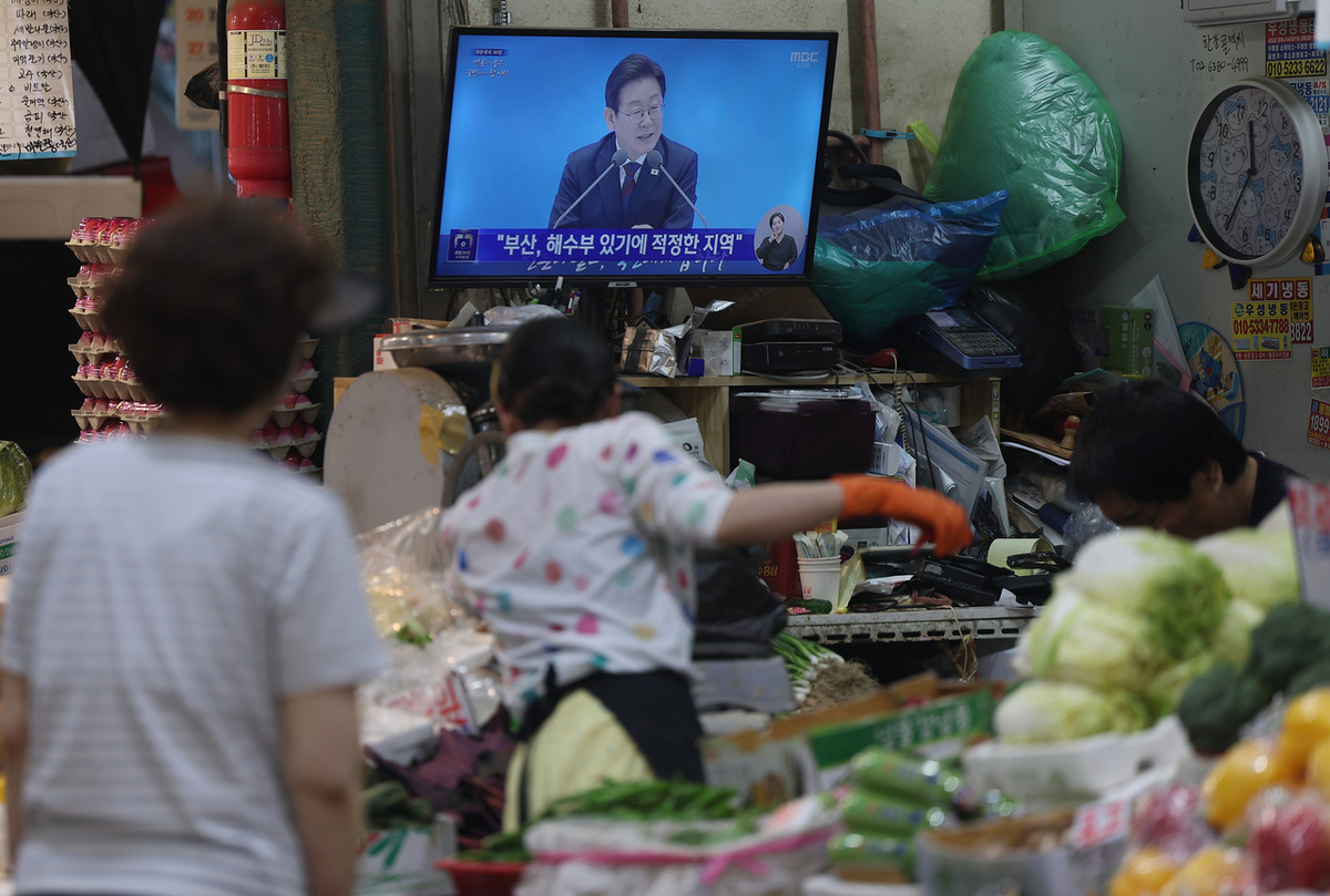Торговцы на рынке Инван в Содэмун-гу смотрят прямую трансляцию 3 июля, как Президент ЮК Ли Чжэ Мён проводит пресс-конференцию, посвященную его первым 30 дням на посту. (Рёнхап)
