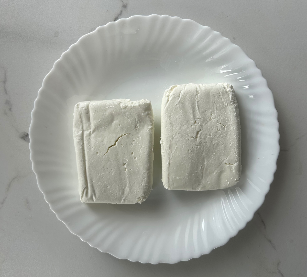 Выкладываем в тарелку два брикета творога.