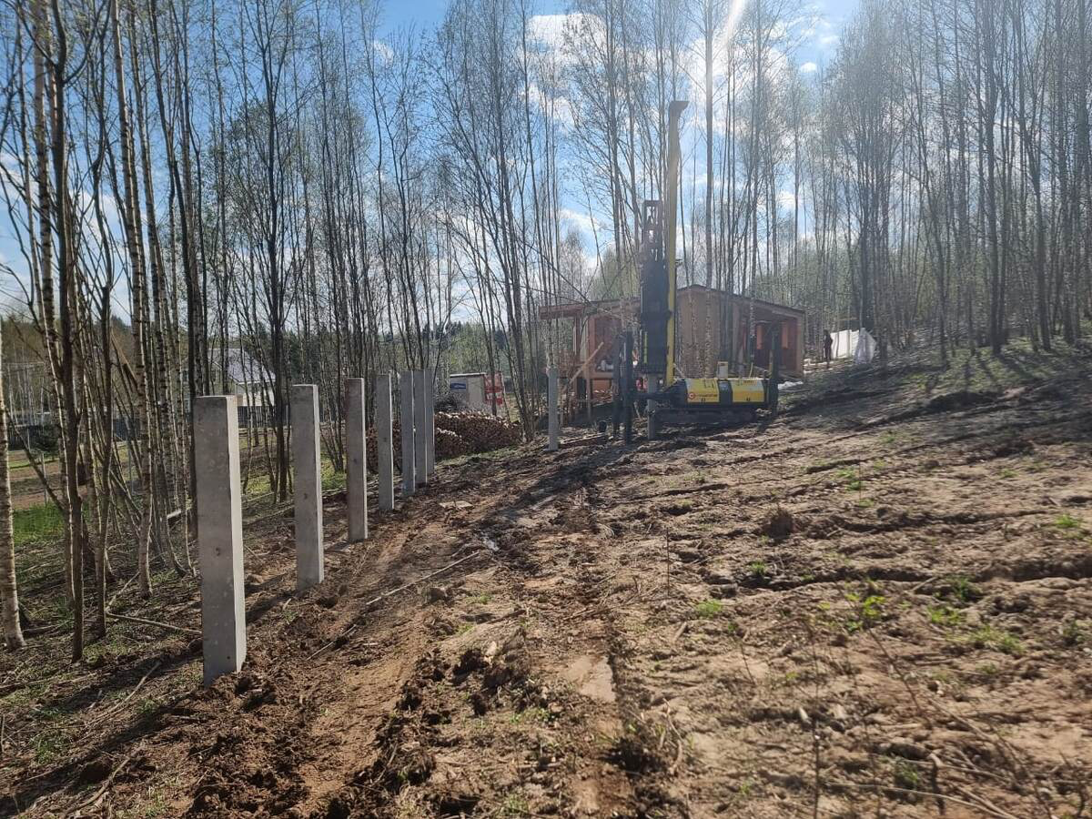 Сваебойная установка возводит фундамент на участке с уклоном в лесу