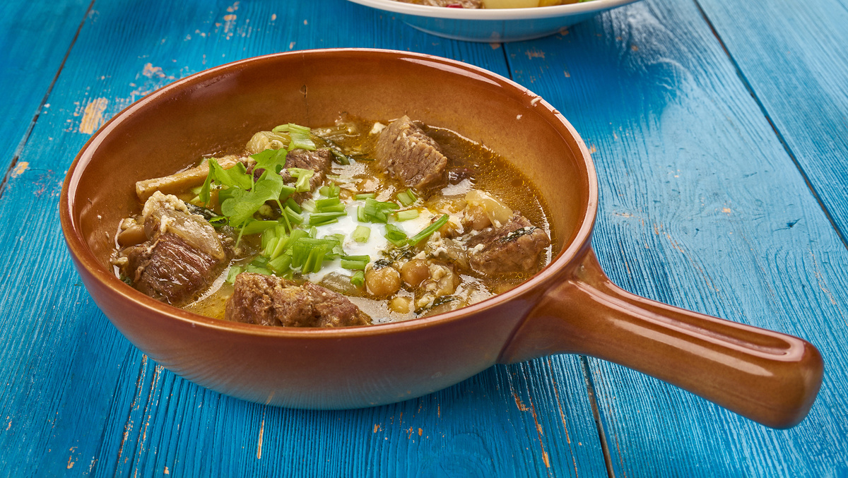     Фото: Fanfo/Shutterstock/FOTODOM Его уникальность — в невероятной густоте и обилии предварительно обжаренных овощей: моркови, лука, картофеля, баклажанов, болгарского перца и нута, щедро сдобренных специями, зеленью и чесноком