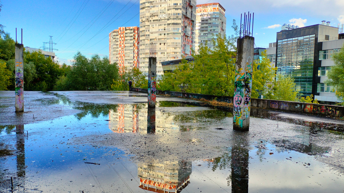 Второй этаж многоуровневой парковки. Вид на жилой комплекс и здание офисно-торогвого центра