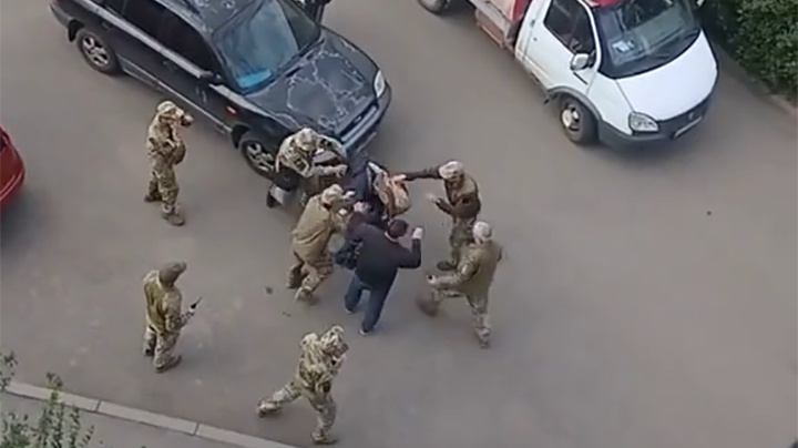  "Людоловы" на улице в Харькове толпой пытаются упаковать очередную жертву. Скриншот: ТГ-канал "Южный рубеж"