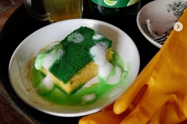 В Малайзии вирусной популярности набирает десерт, который выглядит как… губка для мытья посуды в чашке с пеной. Его подают в кафе Kantin at The Granary (Кучинг, Саравак), и внешне он реально похож на остатки после уборки на кухне.