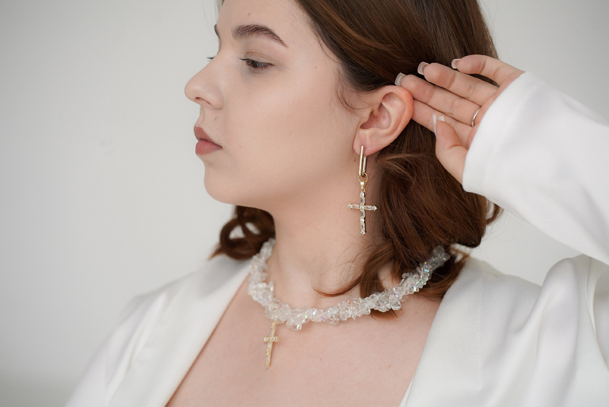 Трёхрядное колье ручной работы с прозрачными камнями — горным хрусталём и ювелирным стеклом, с подвеской-ангелом в форме креста, инкрустированной фианитами. Luceria Line.