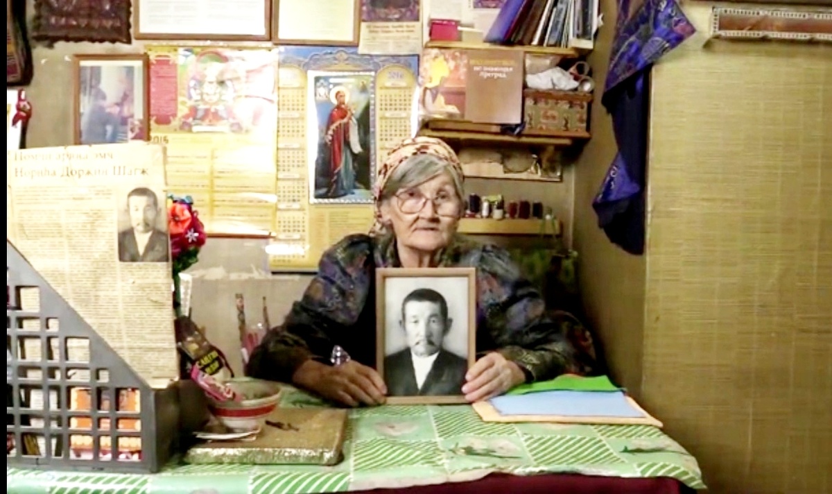 А. А. Широкова с портретом своего духовного наставника Ш. Н. Дорджиева, даёт интервью для сайта Кембриджского университета, 2016 год. Фото из семейного архива Широковых. 