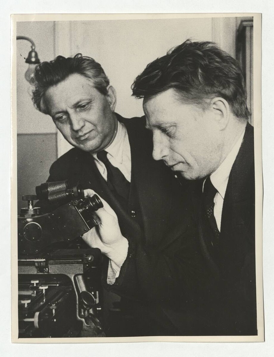 На фото документ из Архива Российской академии наук:
Академик Линник В.П. (слева) и Царевский Е.Н. в оптической лаборатории Государственного оптического института, г. Ленинград. АРАН. Р. ix. Оп. 4. Д. 421