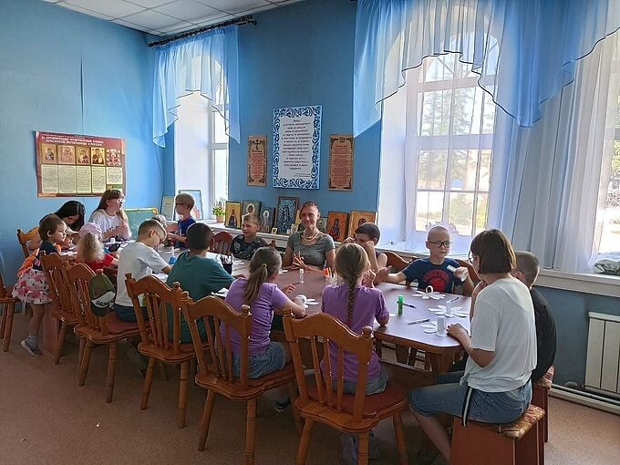 Дети изготавливают ромашки из бумаги