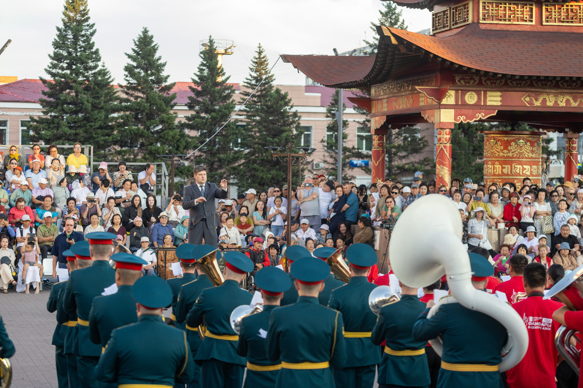 Александр Онищенко дирижирует сводным оркестром на площади. Положительно, публике не хватает места на трибунах, сидели на ступенях театра, стояли под навесом молитвенного барабана (хурдэ)