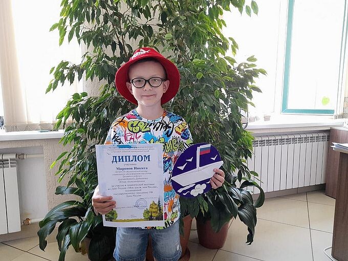 Миронов Никита показывает свою работу и диплом участника