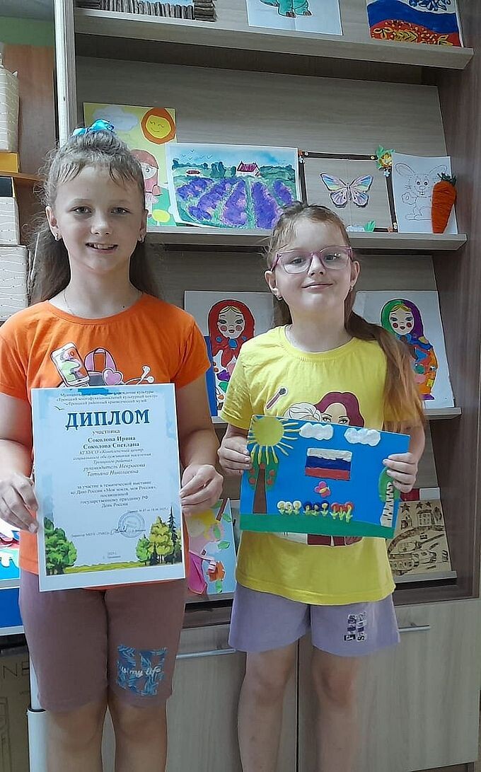 Соколовы Ирина и Светлана показывают свою работу и диплом участника