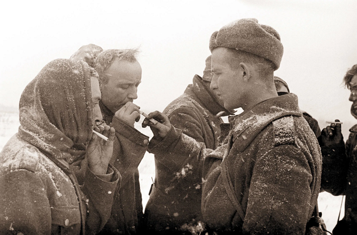 Красноармеец дает прикурить пленным немцам