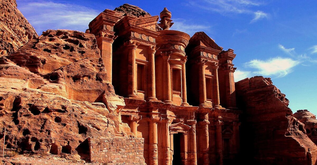 Речь идёт о Петре — городе-крепости, выдолбленном прямо в красноватом песчанике. Источник фото https://clk.li/vqFN