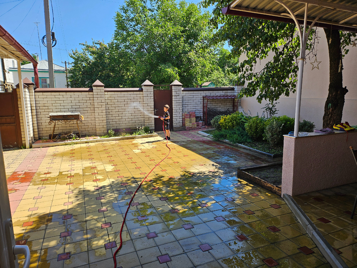 Саша поливает двор 