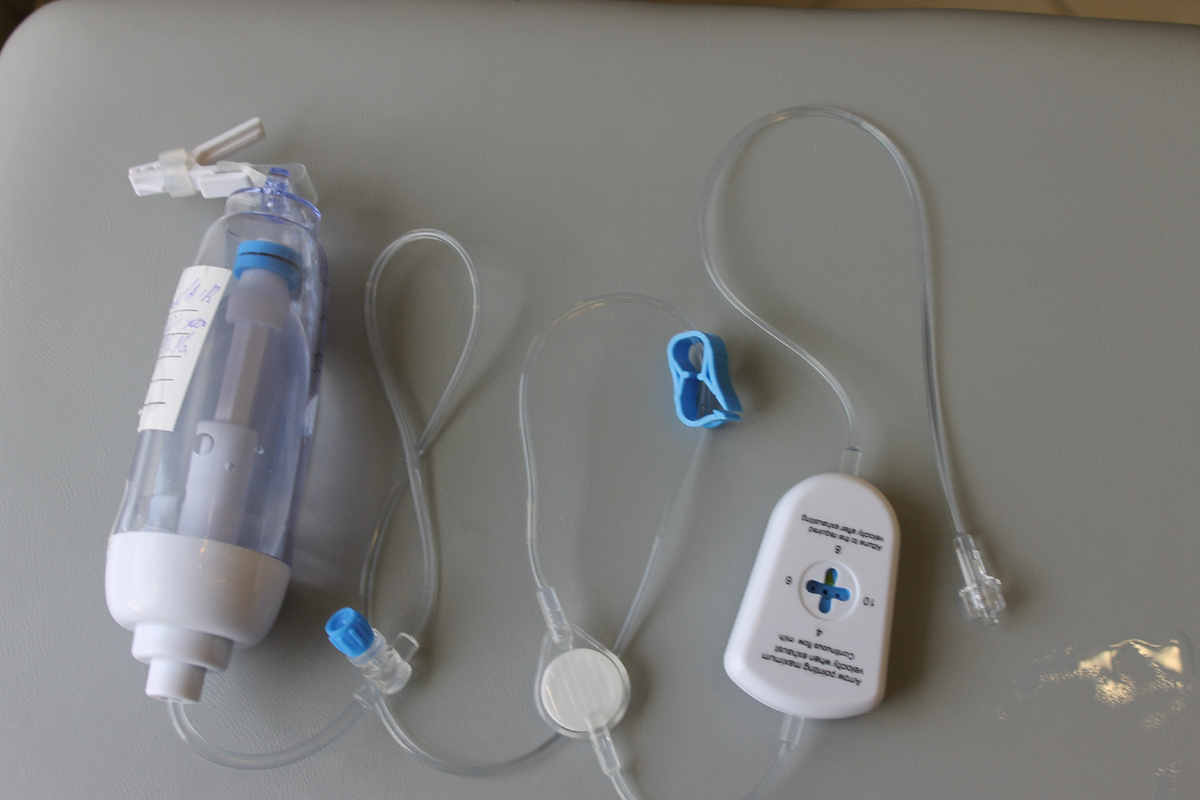 Эластомерная помпа для введения длительного введения обезболивающего препарата. Слева - пластиковая колба с эластичным резервуаром внутри, стенки которого медленно сжимаются и обеспечивают плавное поступление препарата в катетер (трубку). Скорость подачи индивидуально настраивается с помощью регулятора (справа). С такой помпой пациент может активно двигаться уже в ближайшие часы после достаточно обширных и травматичных операций