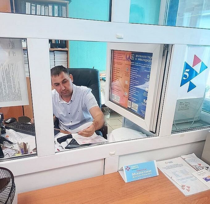 Сотрудник Целинного филиала МФЦ читает пожелание на обратной стороне лепестка