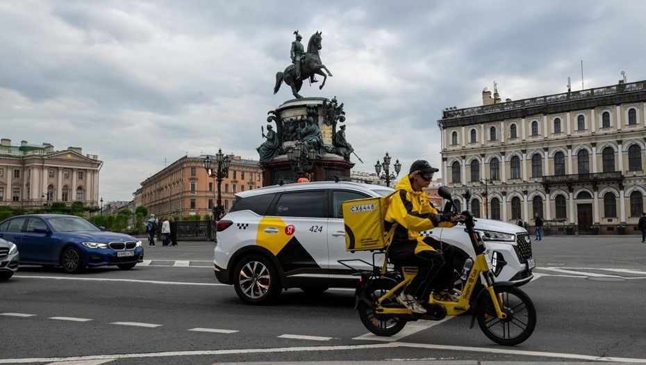    Петербург вид. Исаакиевская площадь. Вид на памятник Николаю Первому. Курьер доставки на мотобайке с рюкзаком на фоне машины такси. Автор фото: Тихонов Михаил