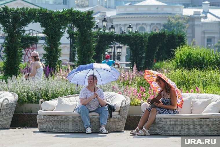 От жары москвичи спасаются зонтиками
Фото:Вячеслав Немышев © URA.RU