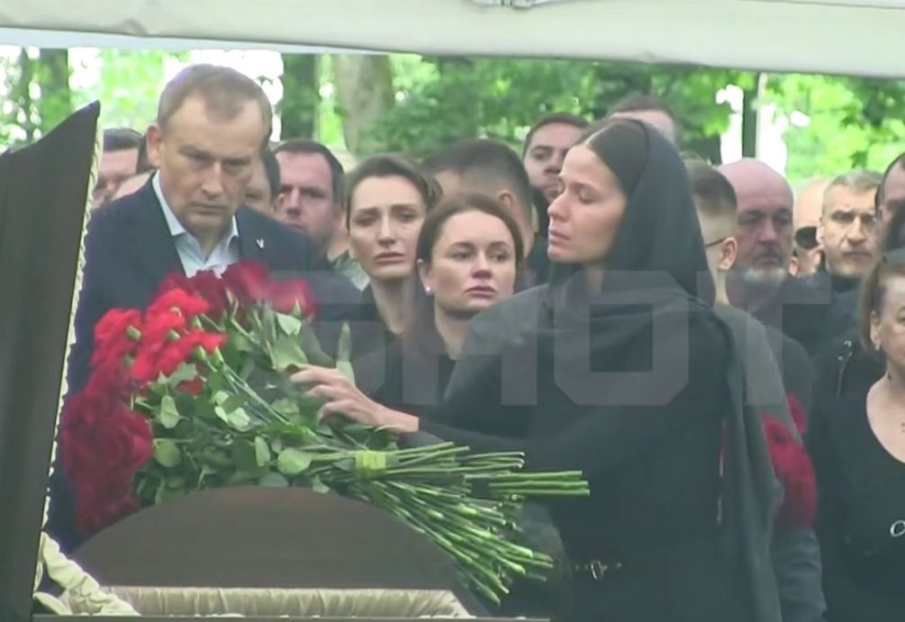   Девушка положила на могилу чиновника букет алых роз. Фото: Shot