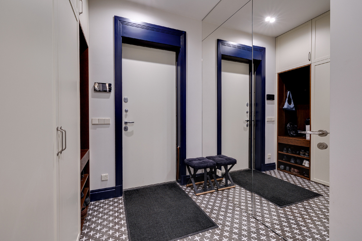 Гостевой санузел расположен прямо у входа, но мастерски скрыт за зеркальными фасадами шкафов, оставаясь практически незаметным. 