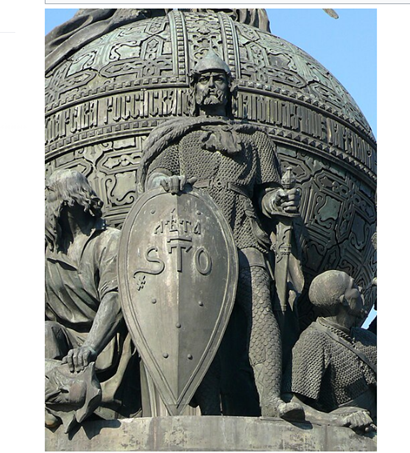  Первый князь Рюрик в остроконечном шлеме с остроконечным щитом (надпись «Лета 6370» — по византийскому летоисчислению, разница между этим летоисчислением и современным равна 5508 лет, следовательно получается 6370-5508=862 год н. э.), в звериной шкуре, наброшенной на плечи. За ним справа находится языческий бог Велес (обращены на юг, к Киеву). Эта группа выполнена скульптором П. С. Михайловым.