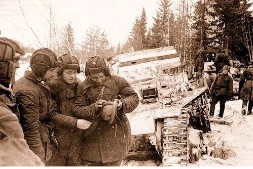 Танкисты 91-го танкового батальона РККА рассматривают финский танковый шлем после боя у станции Перо