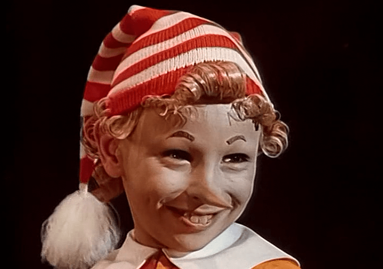 Шапка выглядит, как длинный полосатый колпачок с кисточкой