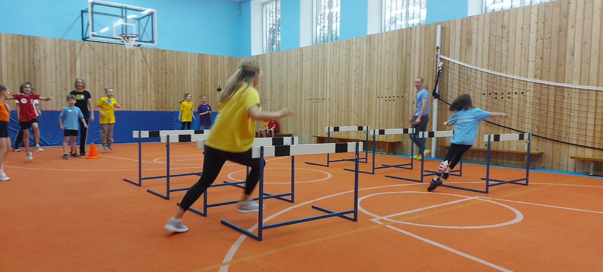 На уроке физической культуры в 1 классе в эстафете принимают участие члены семьи.