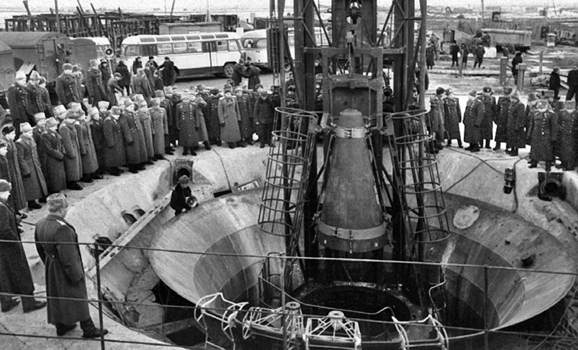 Группа генералов Генштаба наблюдает за работой боевых расчётов по установке имитационной ядерной боеголовки на ракету Р-9, стоящую в подземной стартовой шахте.