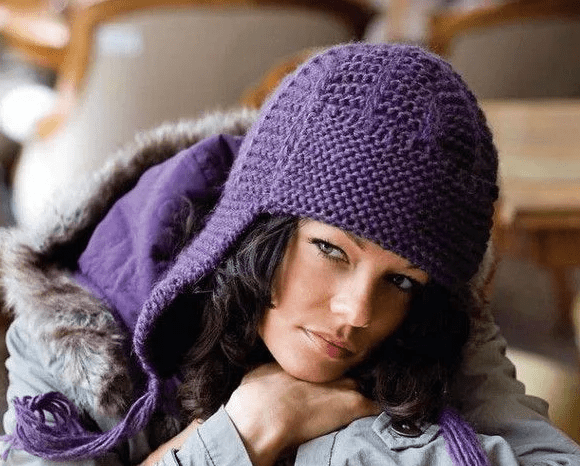Вязаная спицами ушанка создает неповторимый образ