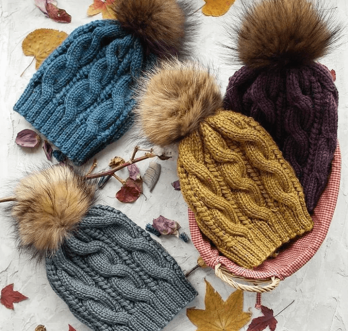 Шапка с меховым помпоном спицами может быть связана нитками любого цвета