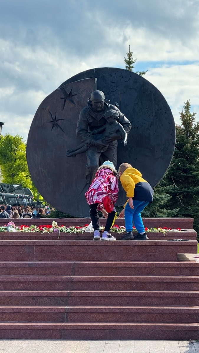 Это фото я сделала 9 мая 2025 года и оно меня очень тронуло, давно хотела вам показать. Дети возлагают цветы к памятнику Дмитрия Разумовского. Он был бойцом спецназа и выпустился из нашей же школы. На руках он выносит ребенка из той самой школы в Беслане…