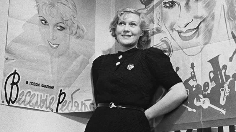 Любовь Орлова на фоне афиши «Веселые ребята», 1934 год