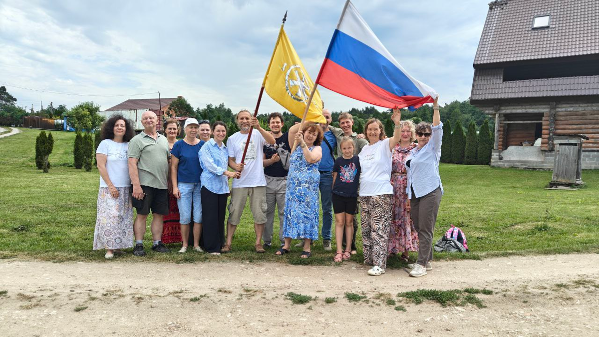 Отъезжает последняя группа участников Встречи Дар. Флаг России и за ним знамя Открытой Семинарии