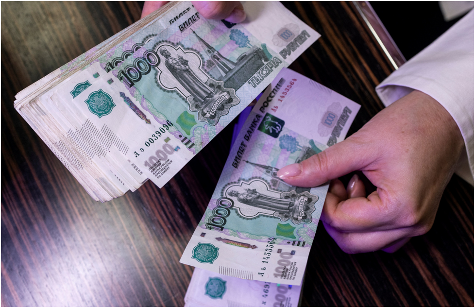 Сотрудник пересчитывает российские банкноты номиналом 1000 рублей в отделении банка в Москве, Россия. Иллюстрация, сделанная 9 октября 2023 года. REUTERS/Maxim Shemetov/Illustration