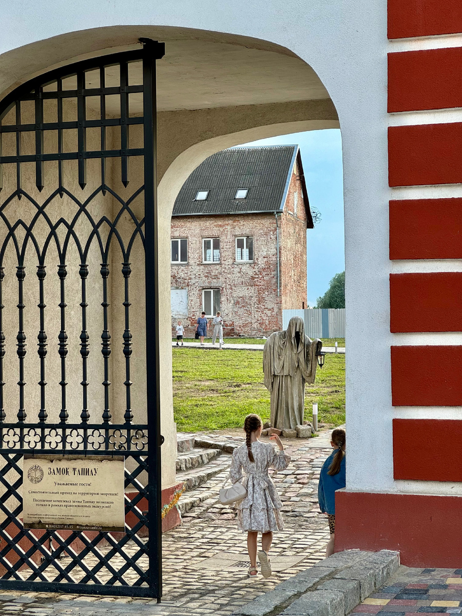 Вход на замковую территорию, июль 2025. Кованные ворота современные.