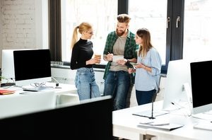    Image of young concentrated colleagues in office talking with each other. Looking aside. admin