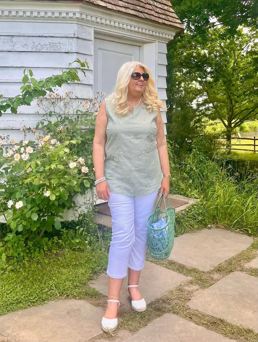 На фото: светлая клетчатая блуза без рукавов и белые капри