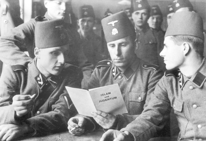 Солдаты 13-й дивизии войск СС Хандшар читают нацистскую брошюру "Ислам и еврейство"