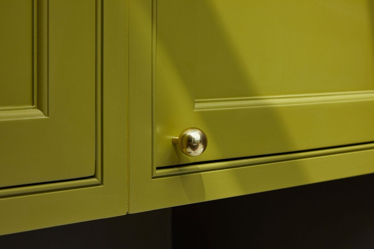 Золотые ручки на кухне в зелёном цвете