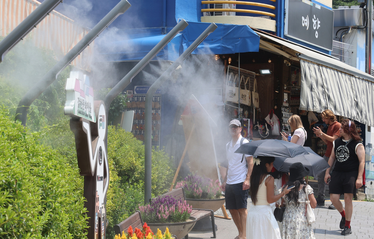 На этой фотографии от 8 июля изображены иностранные граждане, идущие по улице Саха-гу в Пусане (Ренхап)