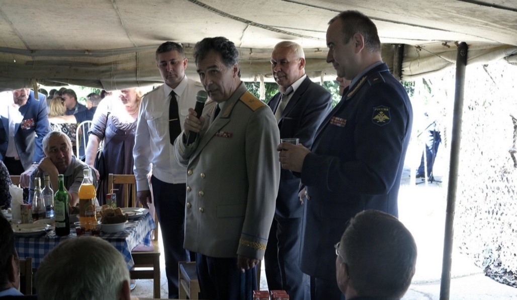 На фото, на веранде рядом с баней ветераны отмечают день полка. 