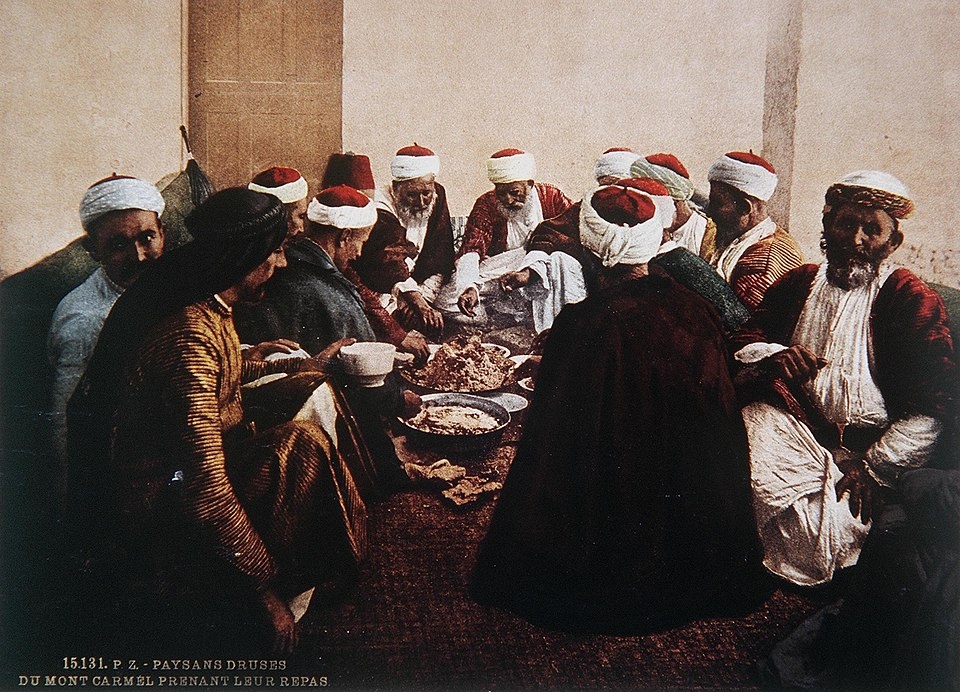 ЖИТЕЛИ ДРУЗА НА КАРМЕЛЕ ОТДЫХАЮТ ЗА ТРАДИЦИОННЫМ СТОЛОМ. ЦВЕТНАЯ ФОТОГРАФИЯ, СДЕЛАННАЯ В КОНЦЕ XIX ВЕКА ФРАНЦУЗСКИМ ФОТОГРАФОМ БОНФИЛСОМ