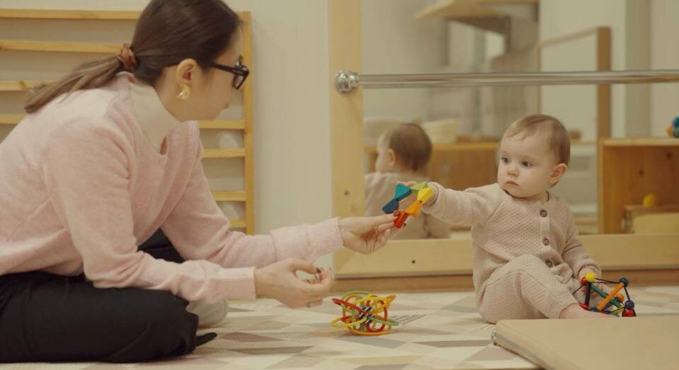 Малышка с мамой на занятиях в Монтессори классе для детей в возрасте до года.